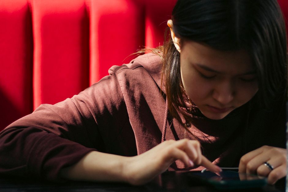 カフェでスマートフォンを操作しながら情報を確認する女性
