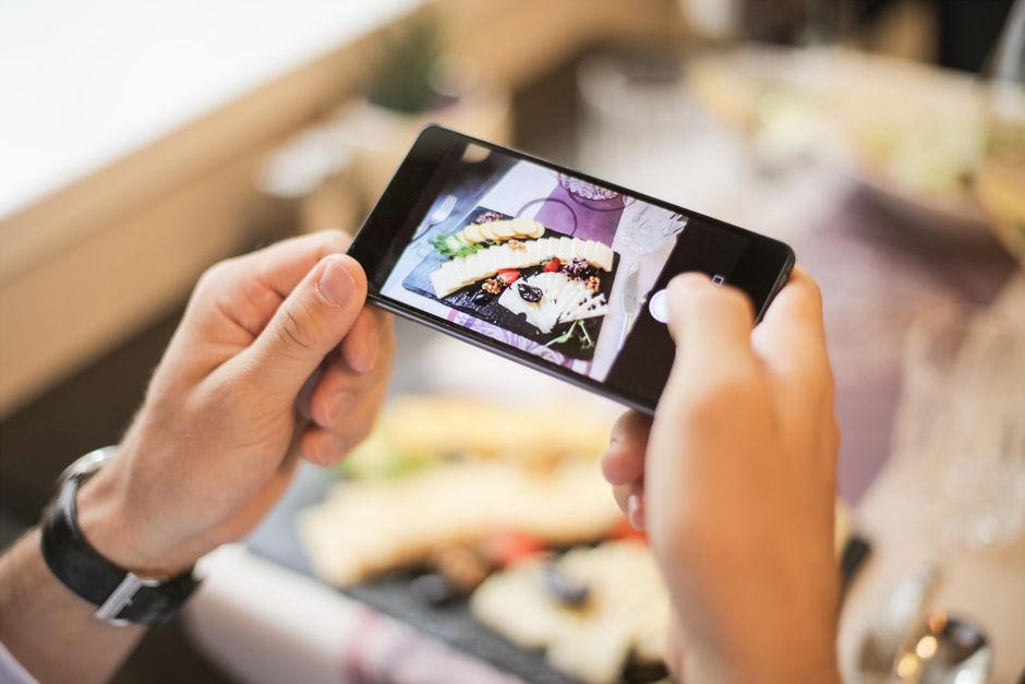 スマートフォンで料理を撮影する飲食店スタッフの手元