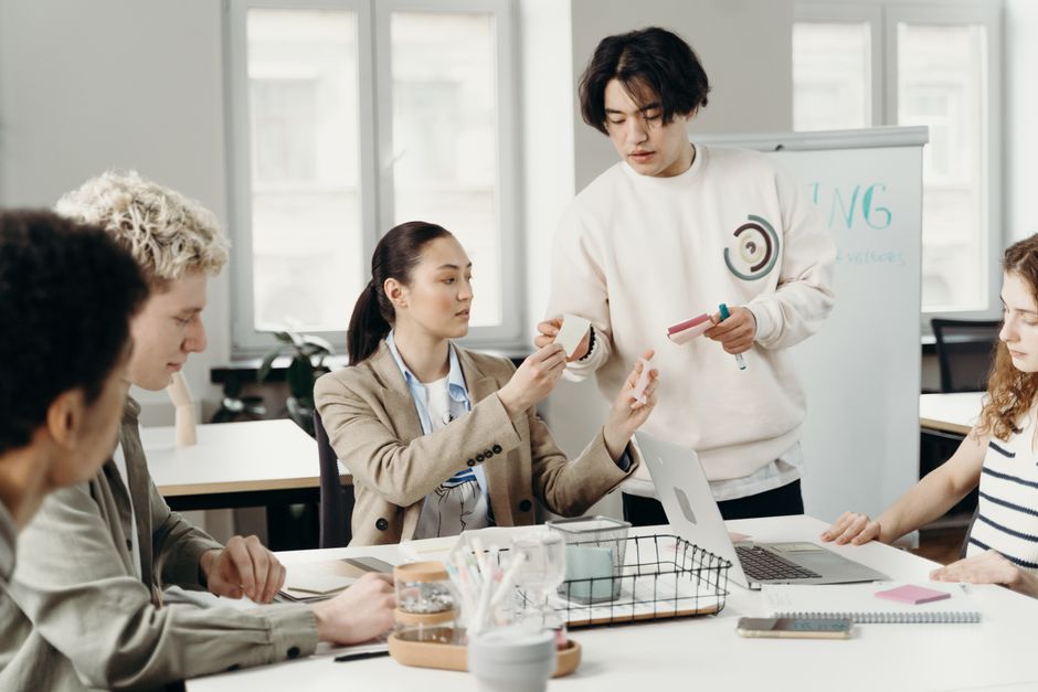 オフィスで若手社員が採用企画について話し合う様子
