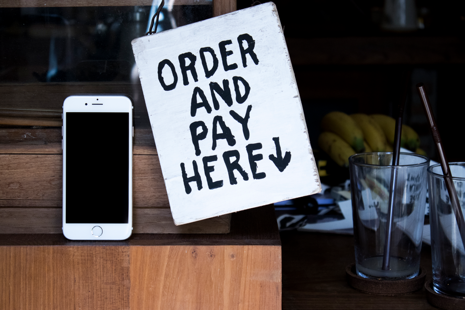 店内でスマートフォンを操作しながら投稿内容を確認する店舗スタッフ